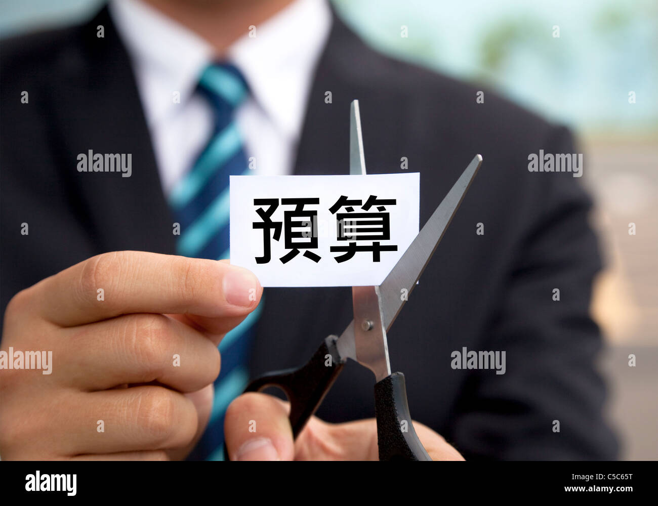 Businessman with scissors label coupe Budget chinois Banque D'Images