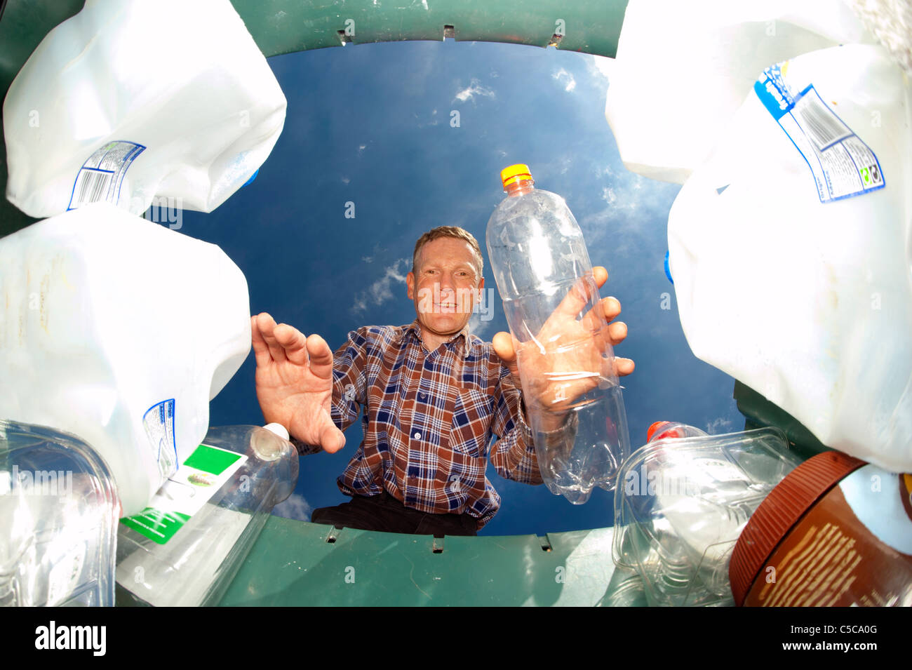 Man throwing bouteille plastique bac de recyclage dans le vert pour le recyclage Banque D'Images