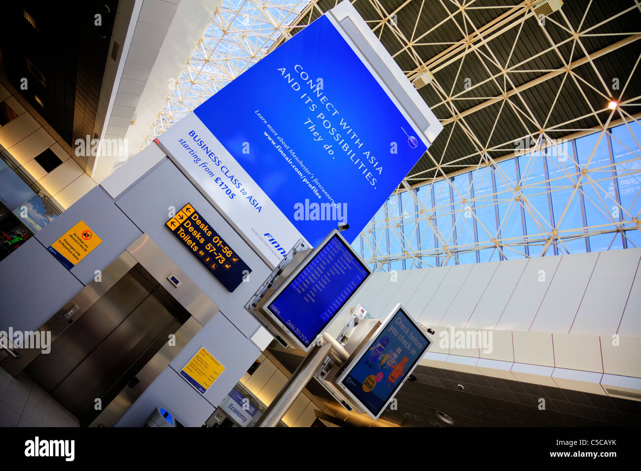 L'aéroport de Manchester, Manchester, Angleterre ascenseur aux autres et l'écran montrant le départ du vol. Banque D'Images