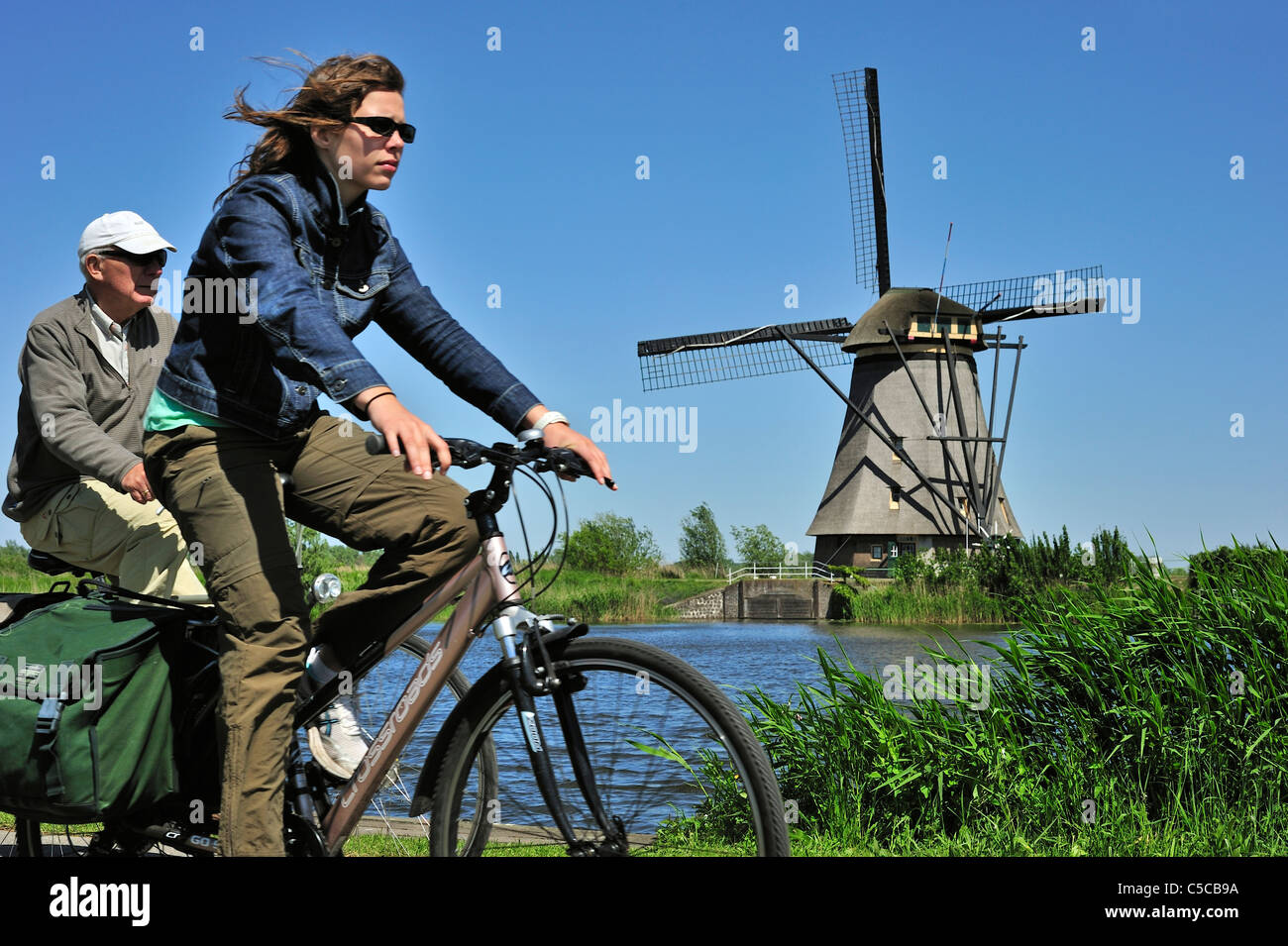 Des vélos et des cyclistes moulin de chaume à Kinderdijk, Site du patrimoine mondial de l'UNESCO au sud de la Hollande, les Pays-Bas Banque D'Images