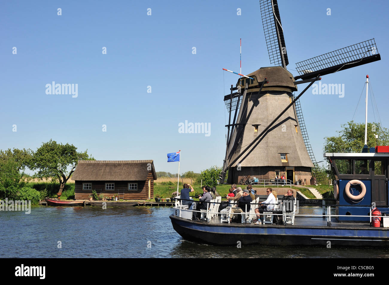Les touristes en bateau et moulins à vent de Kinderdijk polder de chaume, Hollande méridionale, Pays-Bas Banque D'Images