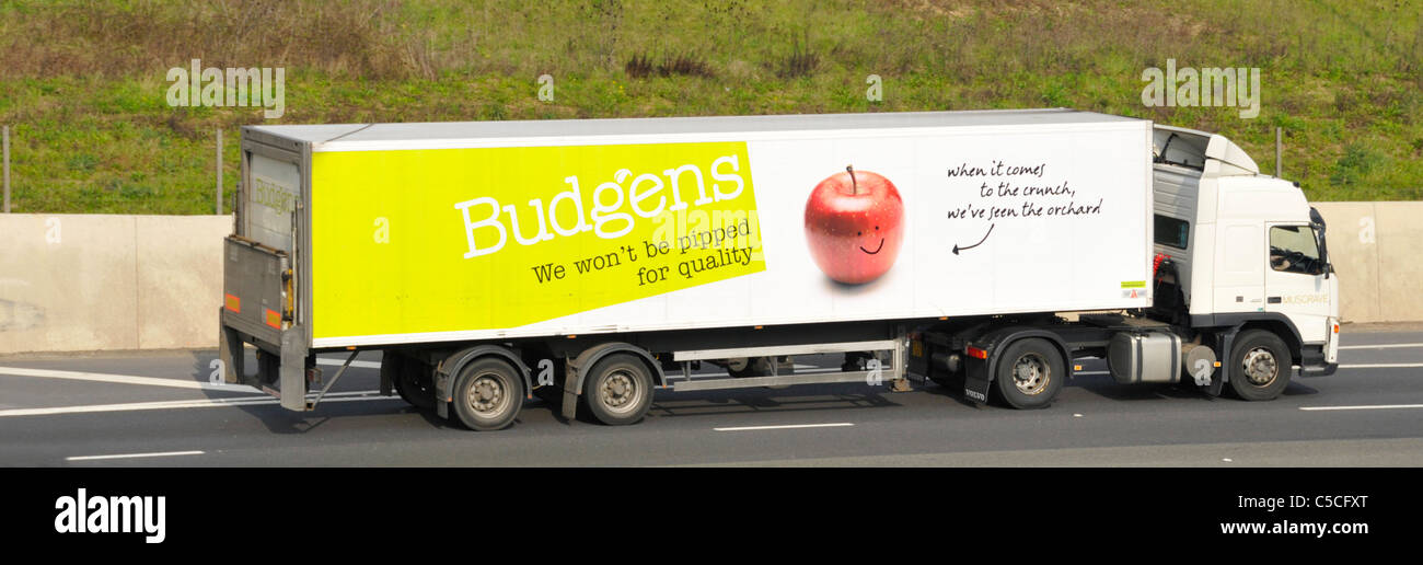 Vue latérale du VHG supermarché de la chaîne d'approvisionnement alimentaire livraison camion magasin camion avec remorque Budgens la publicité des entreprises British les pommes de terre sur l'autoroute britannique Banque D'Images