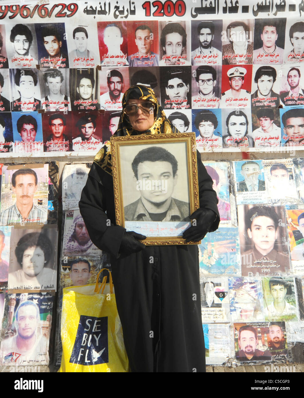 Une mère peut contenir jusqu'ici une photo du fils qui quand miss Kadhafi pendant la pluie. Banque D'Images