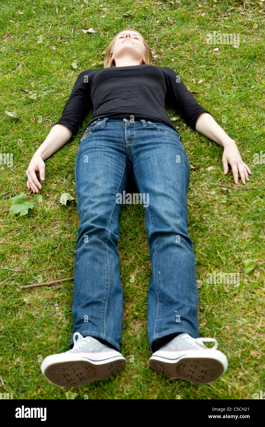 Portrait en pied d'une femme couchée sur l'herbe, Londres, Angleterre, Royaume-Uni. Banque D'Images