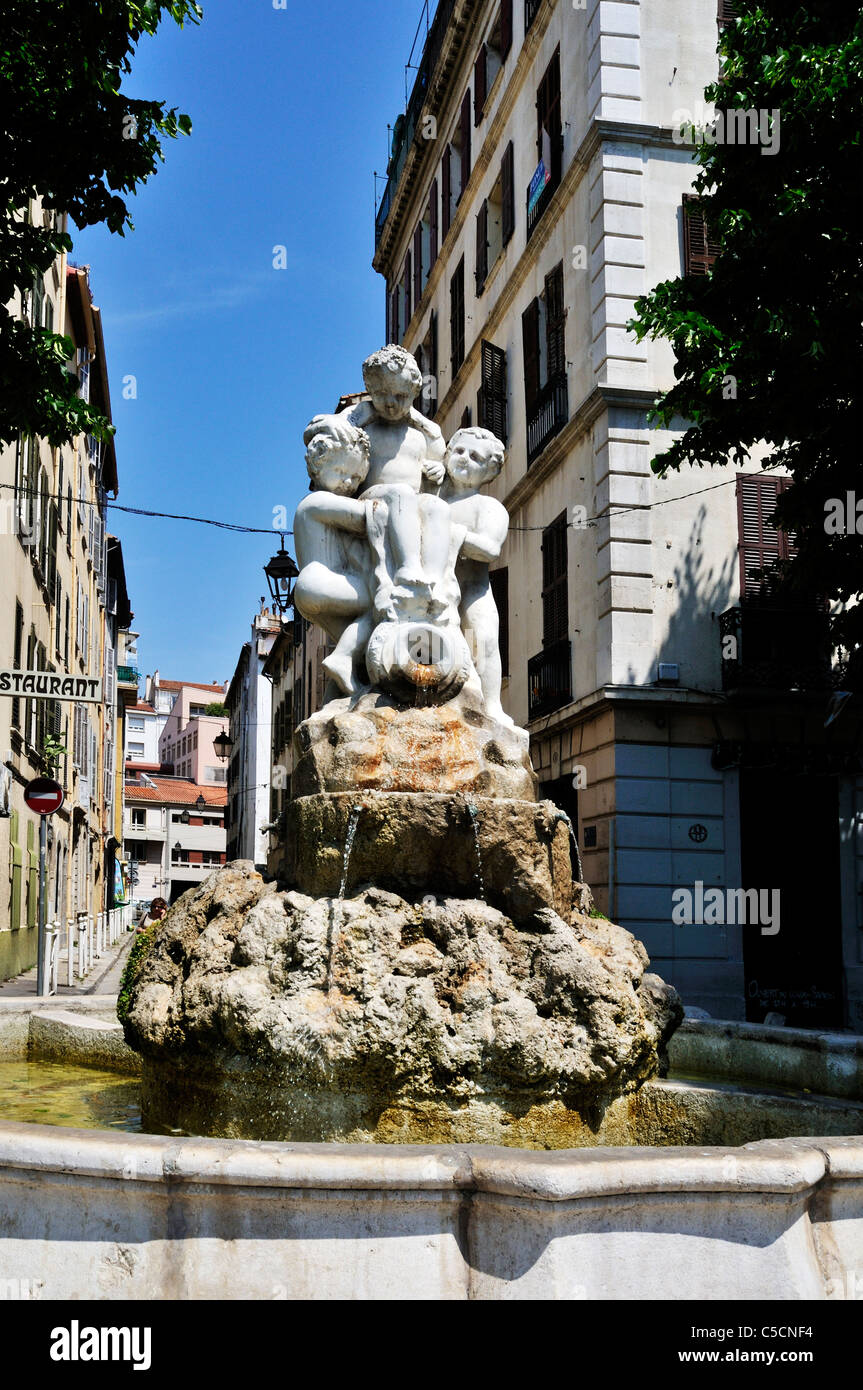Deux chérubins en attente d'un tiers au-dessus une cruche d'où l'eau s'écoule vers le bas des rochers dans un grand bol en béton, Toulon, France Banque D'Images
