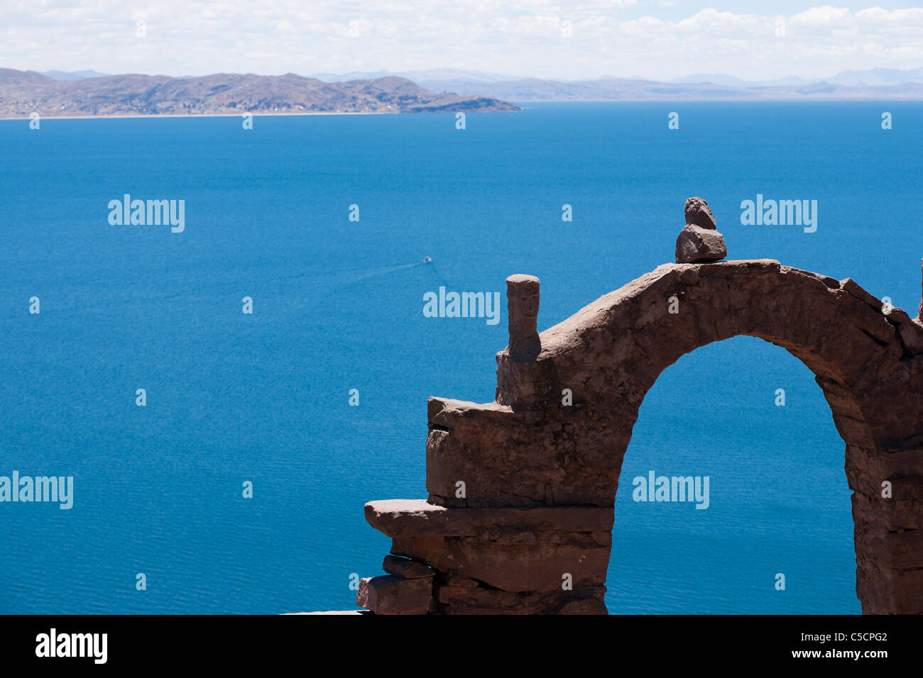 Les touristes posent par la sainte porte de pierre en forme d'une arche en pierre sur l'île de Taquile sur le lac Titicaca Banque D'Images