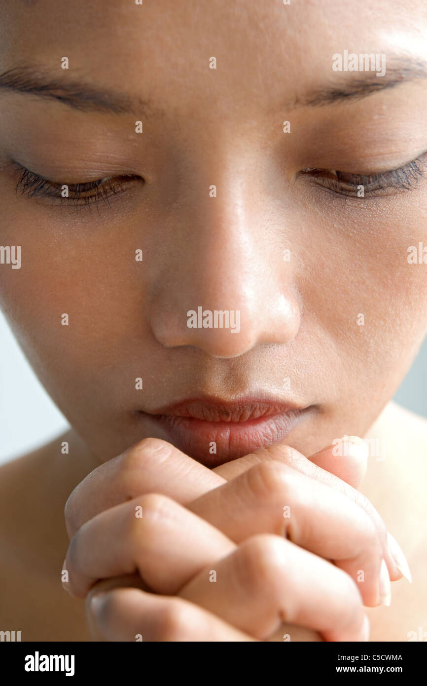 Closeup portrait of a young woman praying Banque D'Images