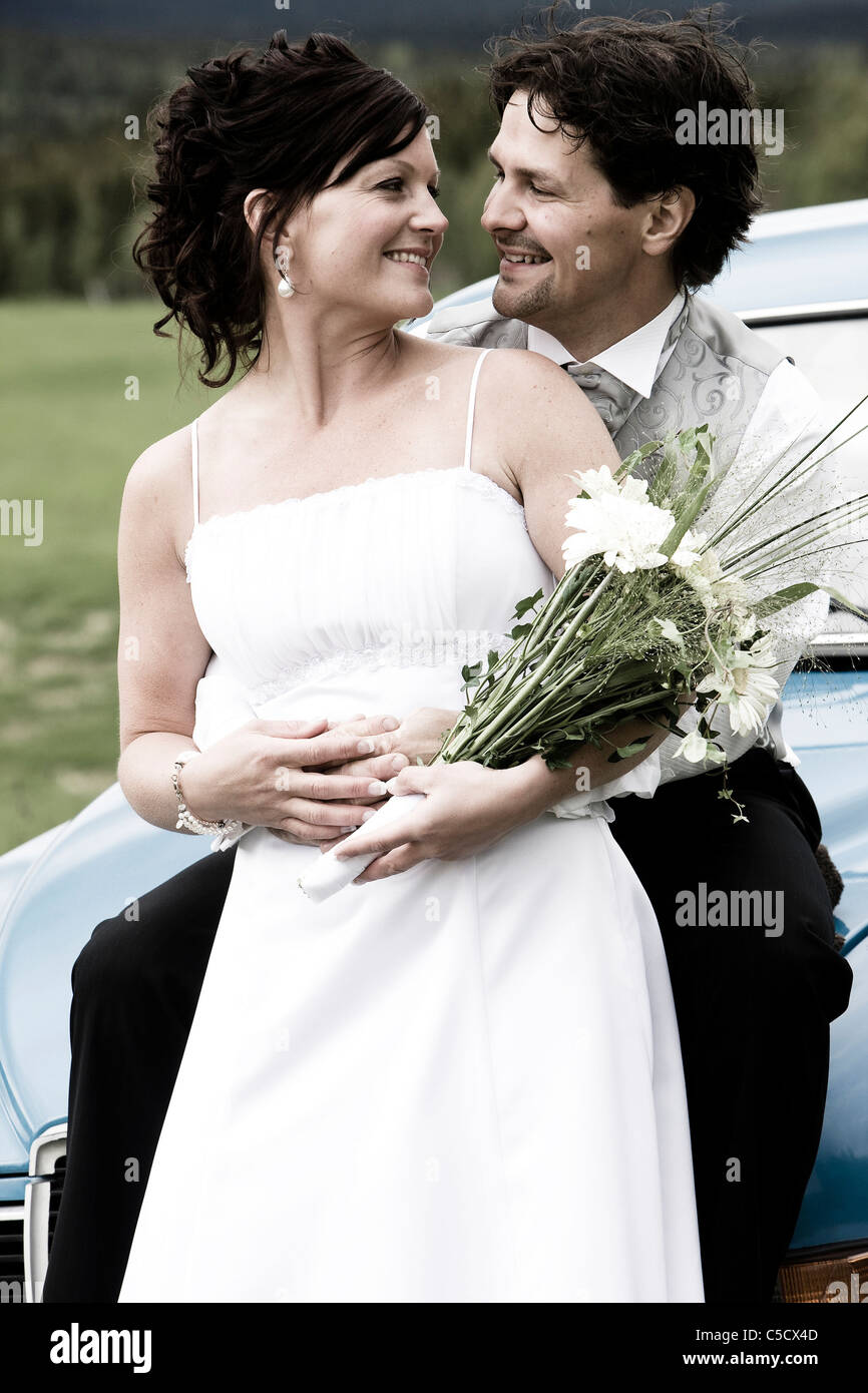 Heureux de Faire place au marié mariée de derrière comme ils regardent les uns les autres Banque D'Images