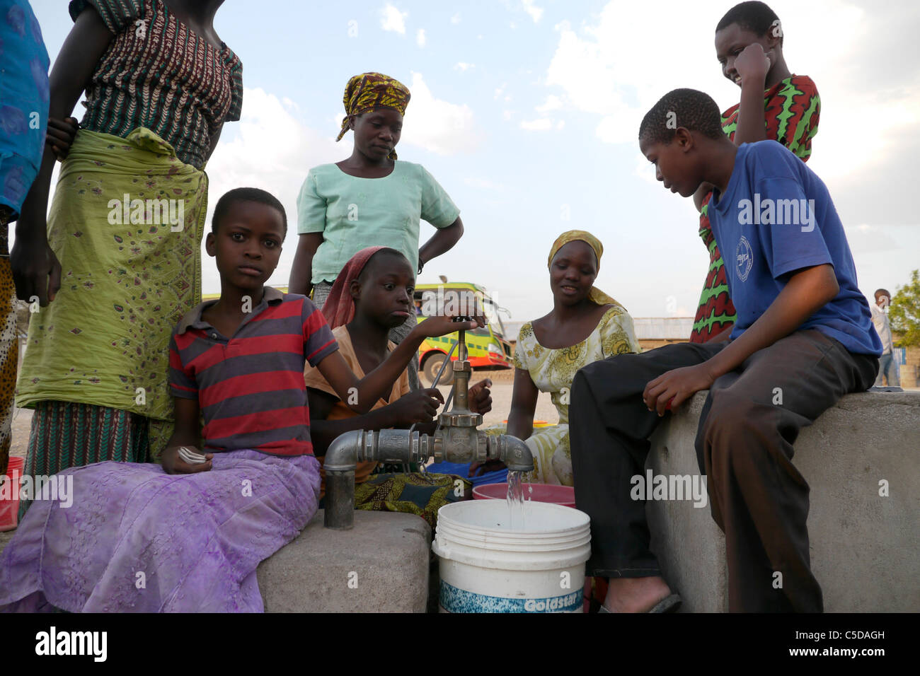 Tanzanie Village d'Mwamalasa, Shinyanga. La collecte de l'eau d'un réservoir de stockage. L'eau est pompée par les éoliennes dans le réservoir. Banque D'Images