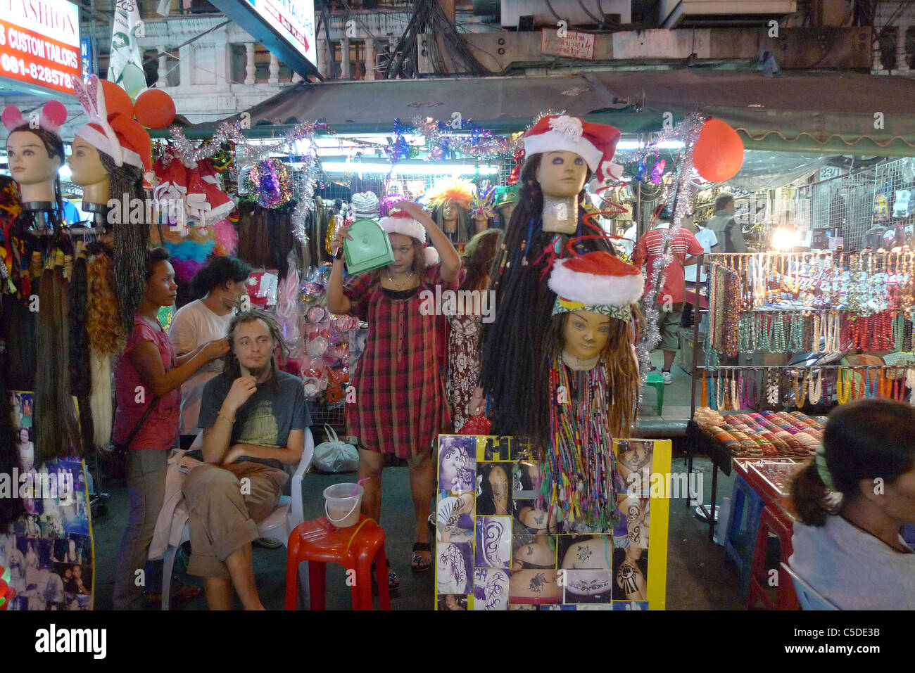 Thaïlande Khao San Road, Bangkok. Zone touristique de budget. La vente de masques, perruques et tressage de cheveux. Photo par Sean Sprague Banque D'Images