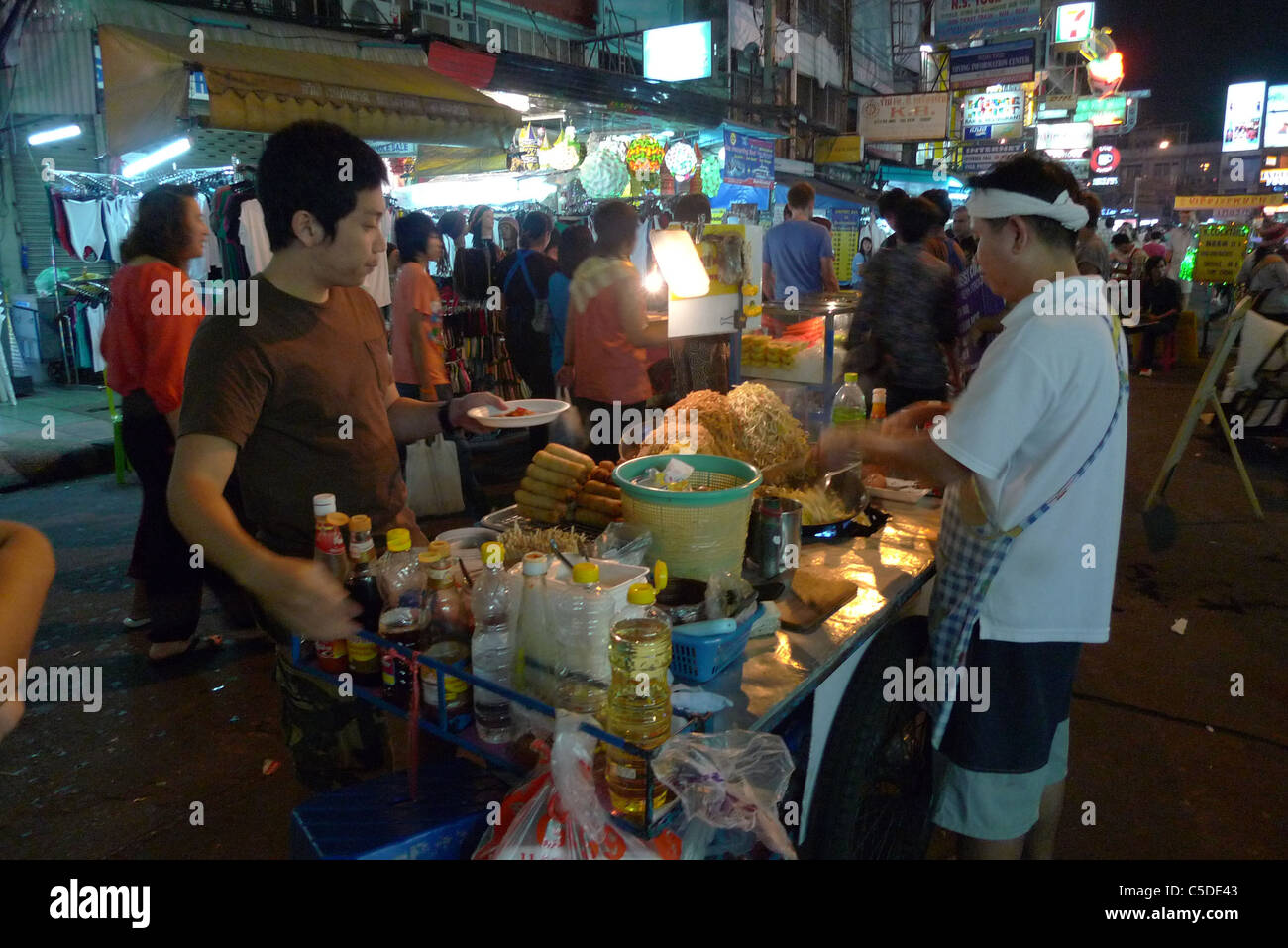 Thaïlande Khao San Road, Bangkok. Zone touristique de budget. L'alimentation de rue. Man making Pad Thai, un plat de nouilles. Photo par Sean Sprague Banque D'Images