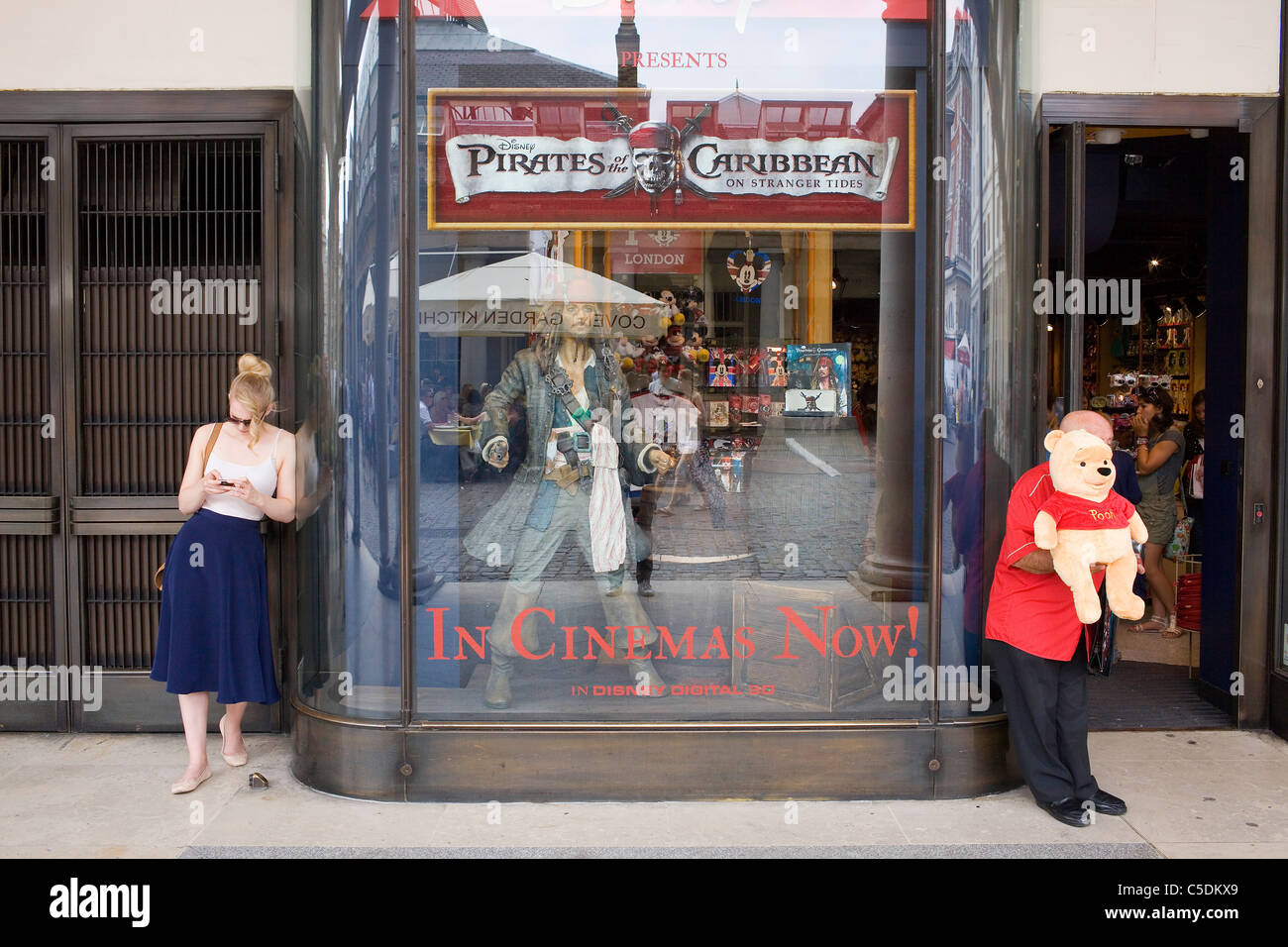 Un homme tenant un Pooh Bear en dehors de la Disney Store de Covent Garden, Londres. Banque D'Images