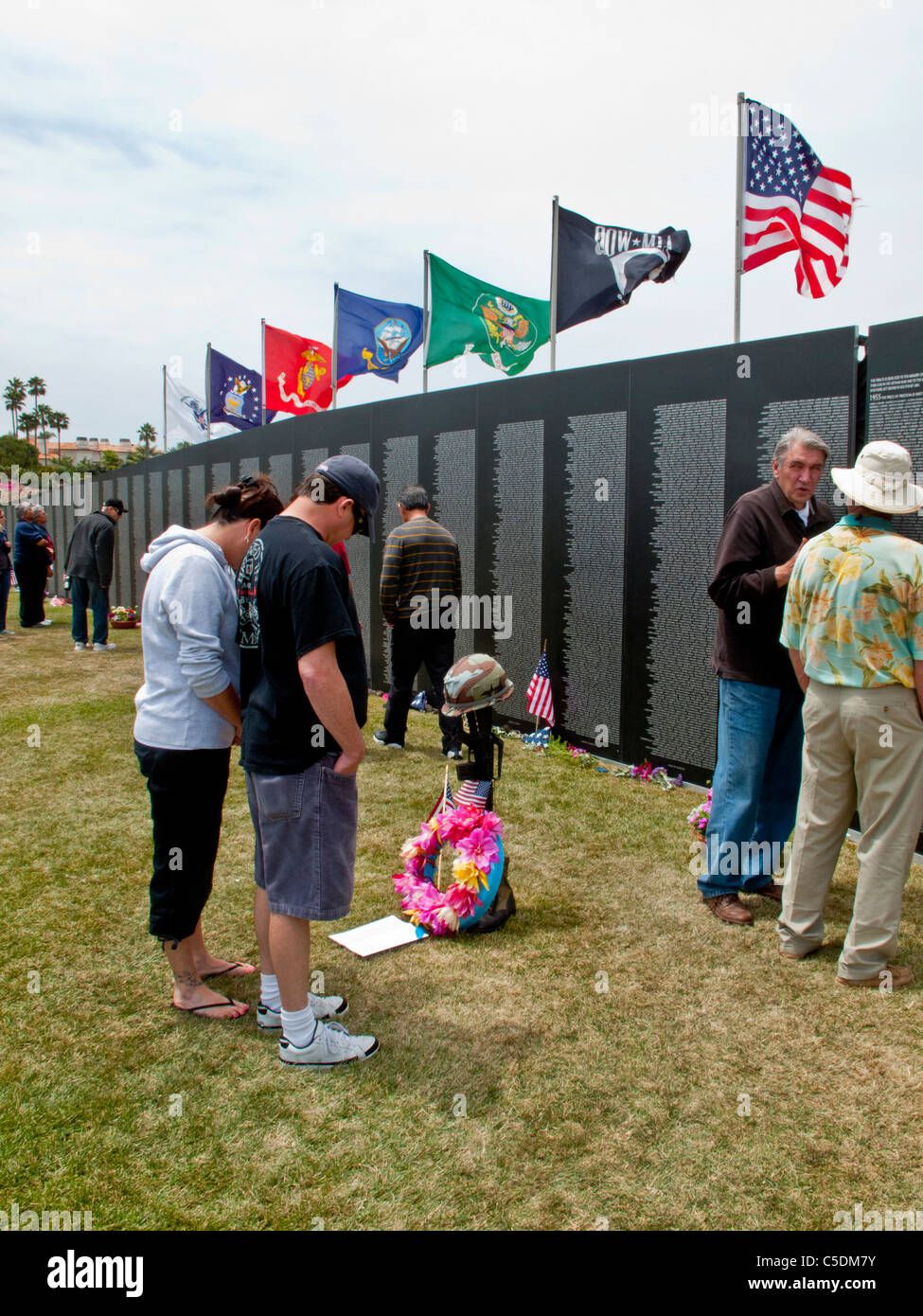 Les visiteurs se lit un poème d'un ancien combattant au mur qui guérit, une réplique de la moitié de l'échelle de la Vietnam Veterans Memorial. Banque D'Images