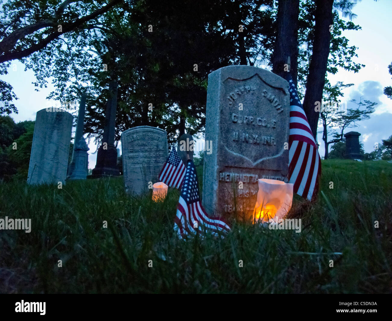 Des sépultures de guerre civile sont éclairées avec des bougies pour commémorer le Jour du Souvenir au Cimetière Vert-bois à Brooklyn, New York. Banque D'Images