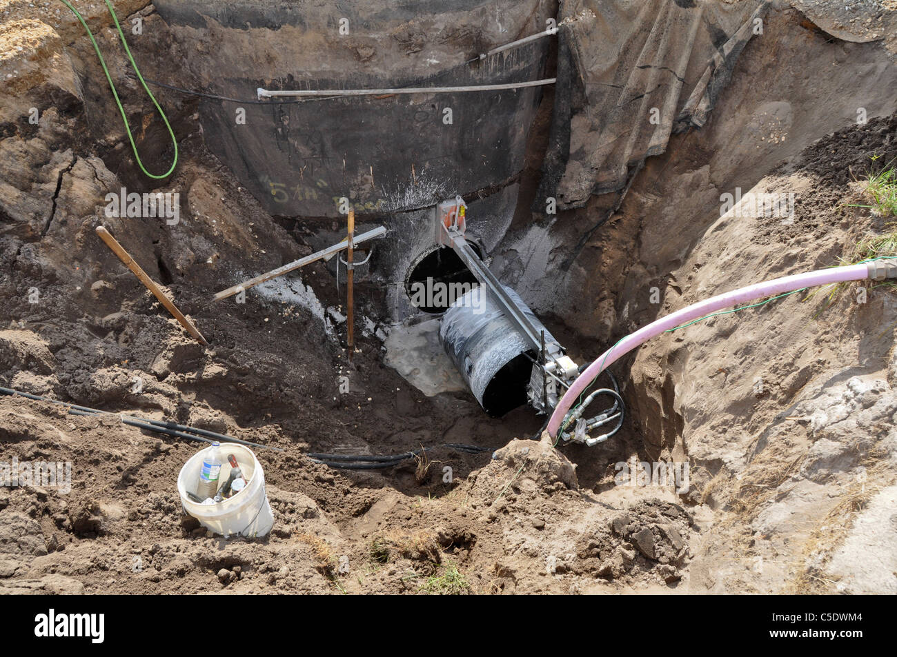 Le forage d'un noyau en béton de trou d'santary pour une nouvelle ligne de service. Banque D'Images