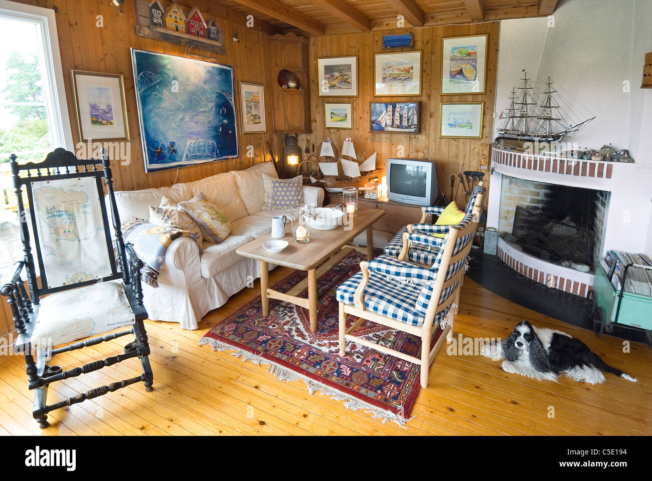 Avis de mobilier par cheminée et chien sur plancher en bois à un salon en  chambre Photo Stock - Alamy
