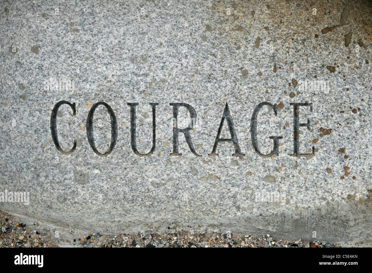 Le mot courage en granit sculpté sur une pierre de cailloux Banque D'Images