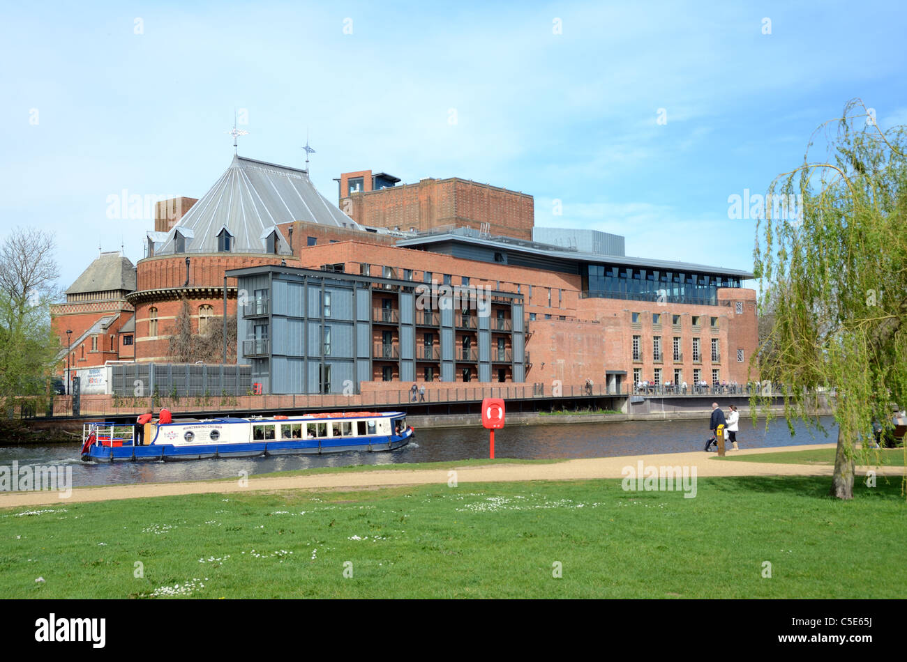 Un long bateau ou Canal Boat passe devant Le Royal Shakespeare Theatre sur la rivière Avon à Stratford-upon-Avon Warwickshire Angleterre Banque D'Images