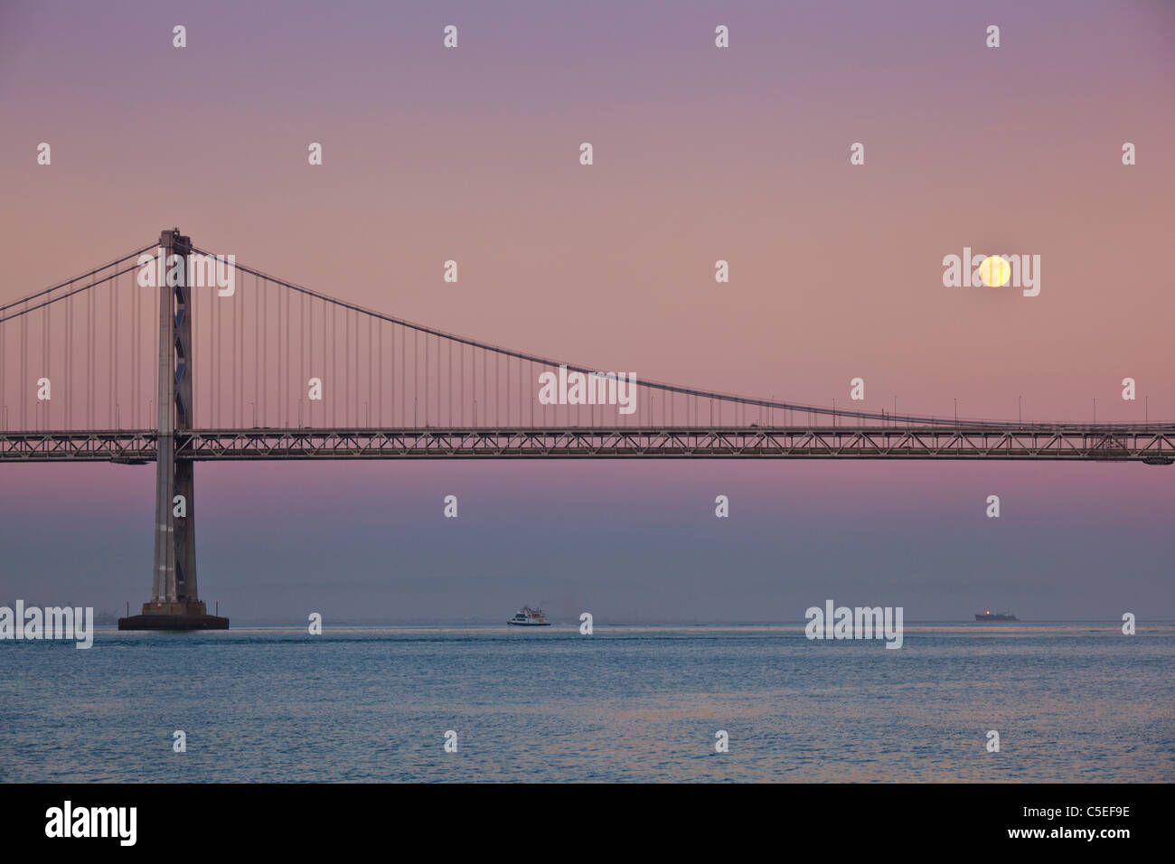 San Francisco Pleine lune s'élève au-dessus de l'Oakland Bay Bridge coucher soleil Californie, États-Unis d'Amérique, USA Banque D'Images