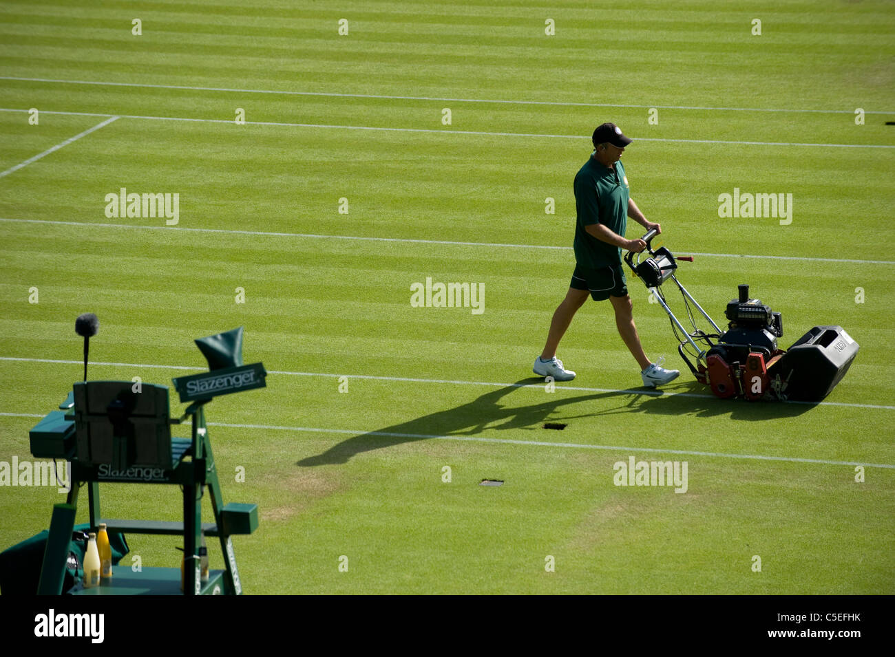 L'herbe sur le Court central est coupé pendant l'édition 2011 des Championnats de tennis de Wimbledon Banque D'Images