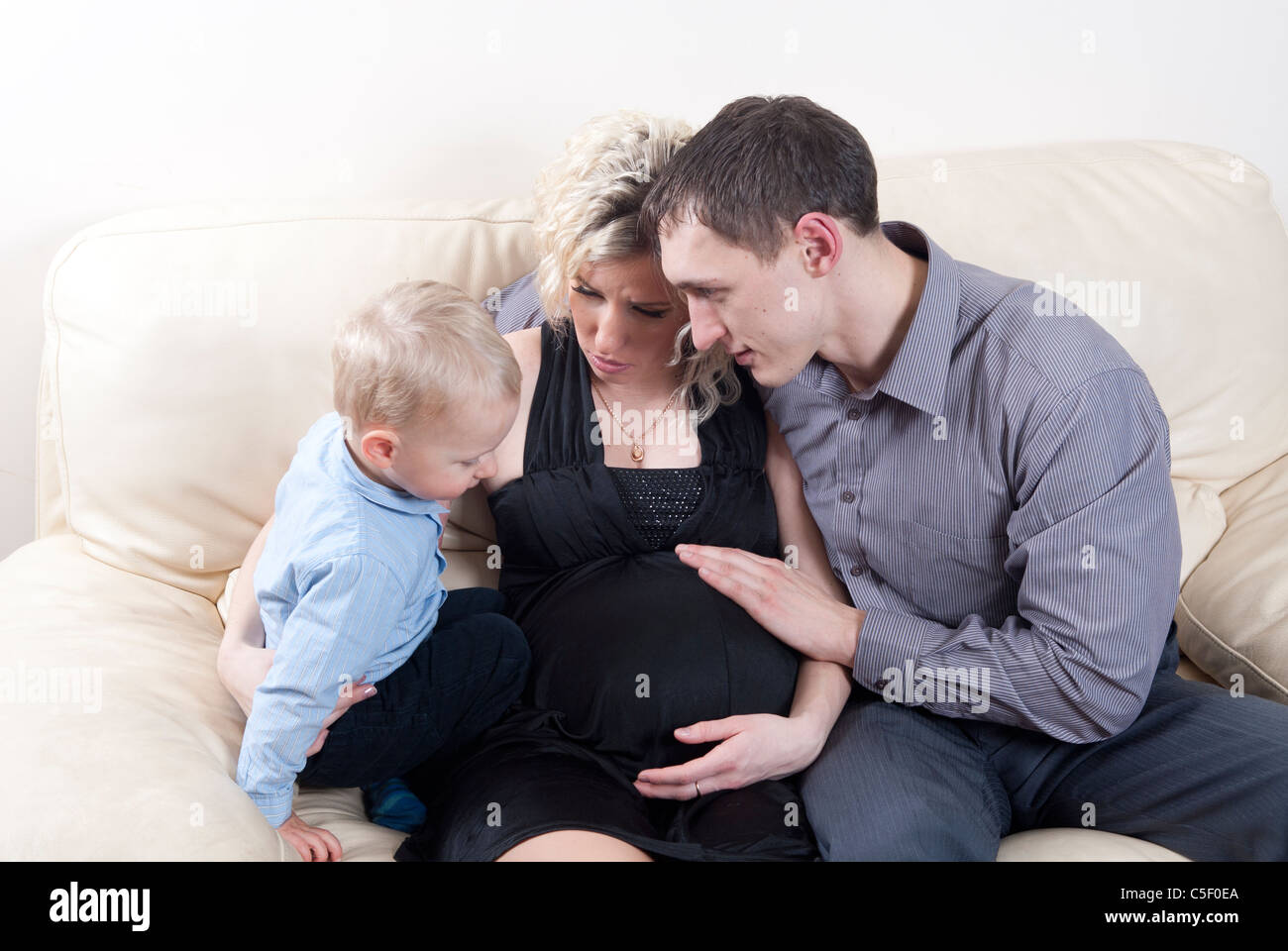 Femme enceinte avec son fils et mari de parler à la maison Banque D'Images