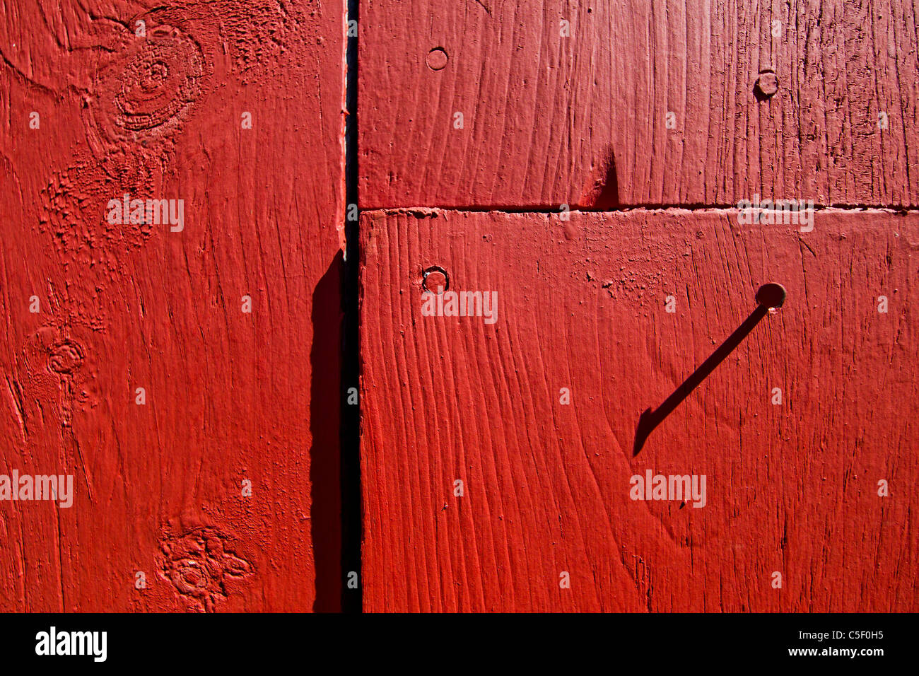 L'ombre d'un ongle contre grange rouge peint en bois. Banque D'Images