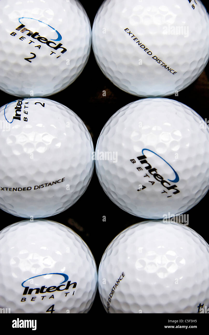 Le thème d'un parcours de vie encore abstrait, composé d'une demi-douzaine de balles de golf flambant neuf, symétriquement regroupés dans les lignes. Banque D'Images