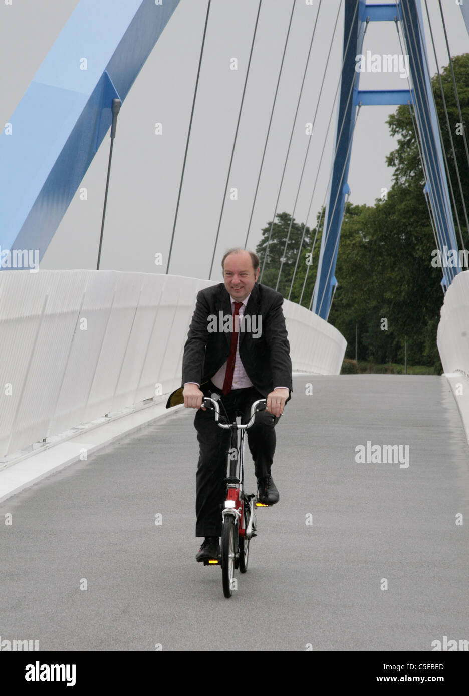 Norman Baker d'ouverture du cycle MP Redhayes passerelle M5 Devon 20 juillet 2011 équitation un vélo Brompton fait britannique Banque D'Images