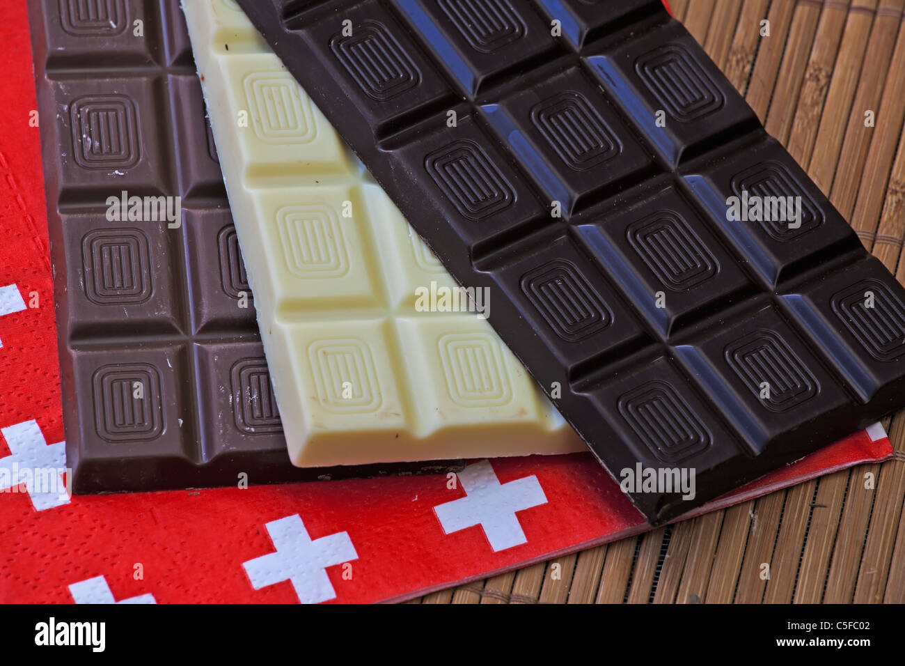 Trois panneaux chocolat suisse sur un set de table avec une serviette avec drapeau suisse Banque D'Images