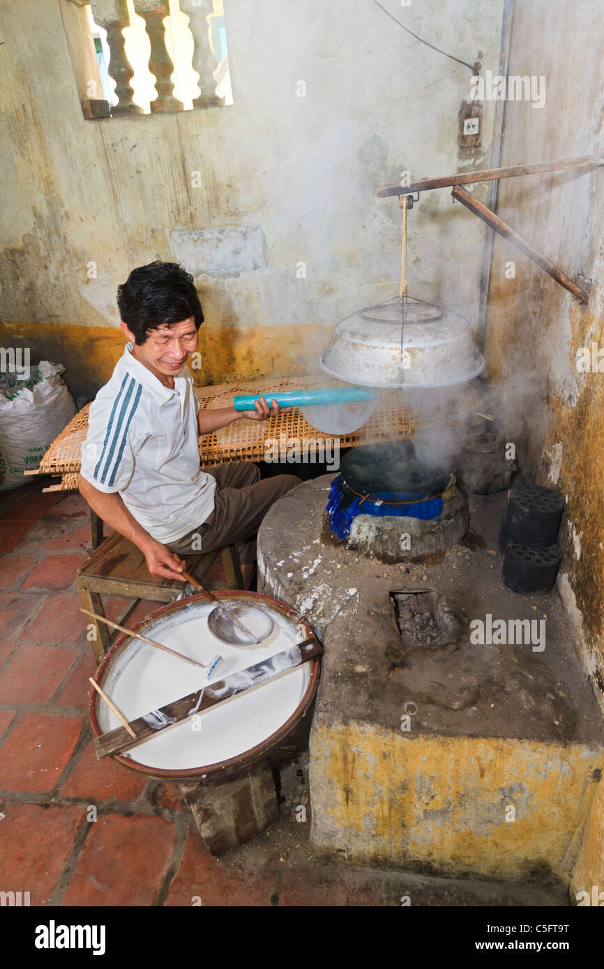 Viet Trinh Quang, 53 ans, montre comment il fait du papier de riz (pour la cuisson) dans la cuisine de sa maison, Tho Ha village, Vietnam Banque D'Images