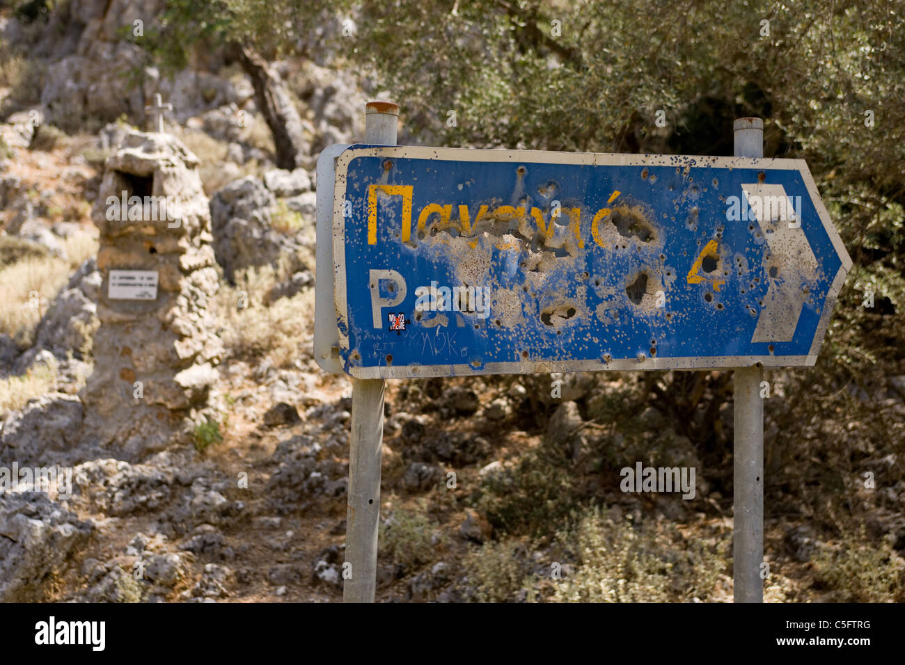 Une route de montagne signe qui a été tourné en morceaux de sorte qu'il était impossible de lire. Crète, Grèce. Banque D'Images