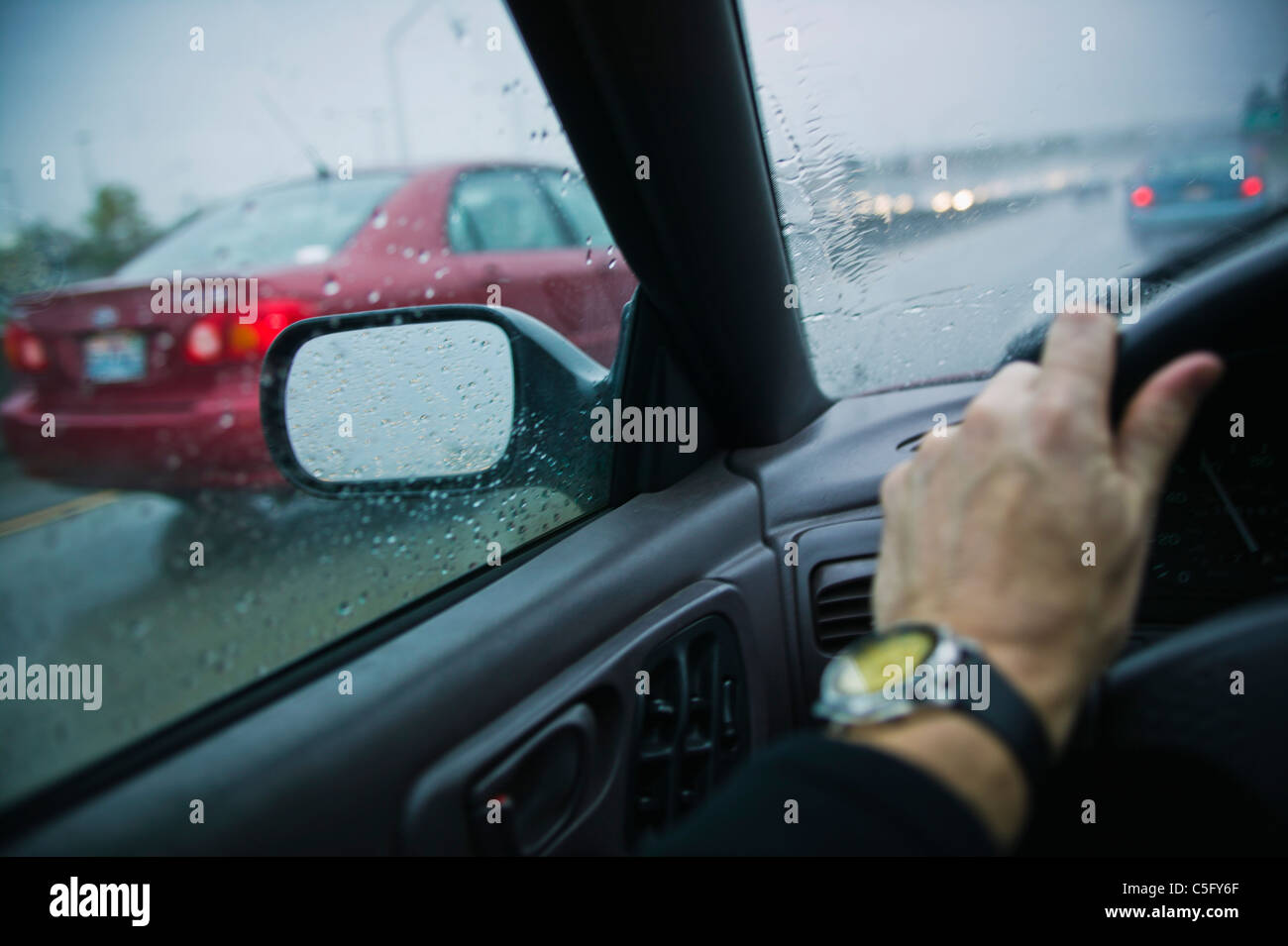 La première personne de conduire sur une autoroute dans la pluie. Banque D'Images