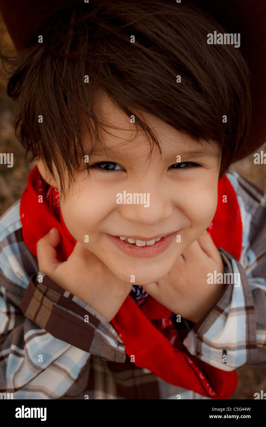 Jeune garcon habille en chemise a carreaux et d un bandana rouge autour du cou le partage d un sourire Photo Stock Alamy