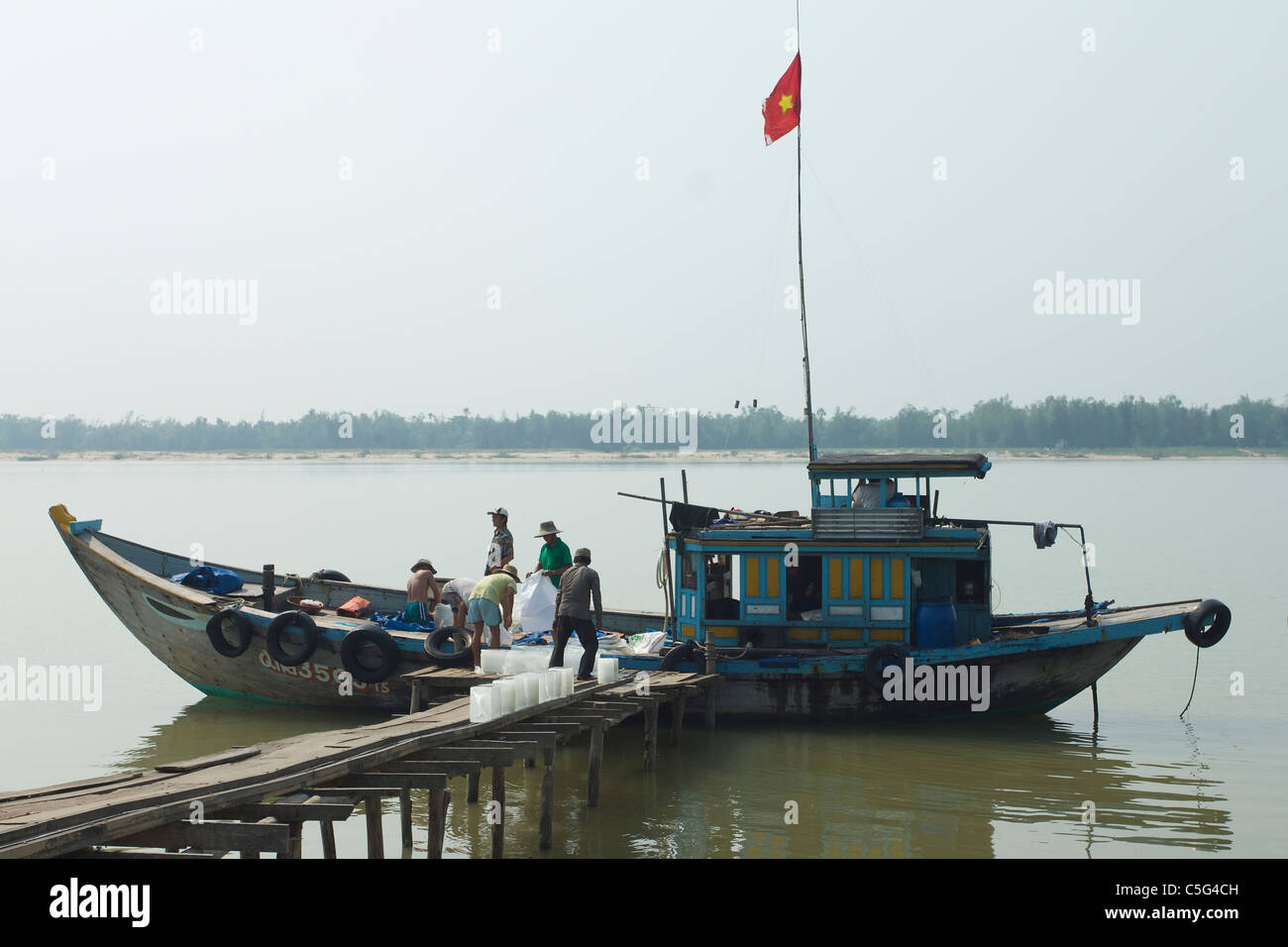 Blocs de glace d'être chargés à bord d'un bateau de pêche dans la région de Hoi An, Vietnam Banque D'Images