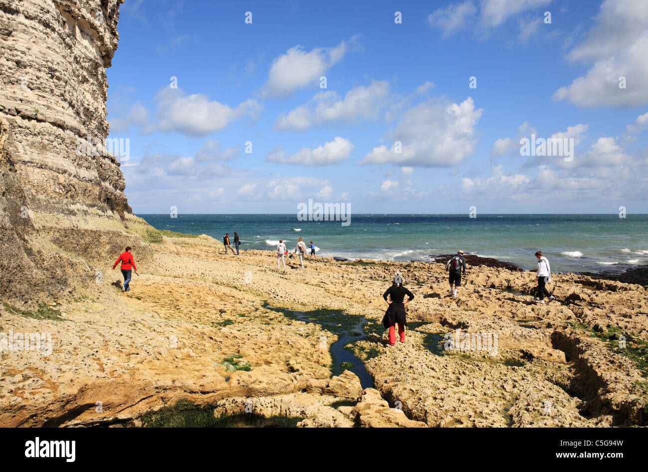 Les gens marcher sur les rochers sur la côte atlantique française à Étretat, en Normandie. Banque D'Images