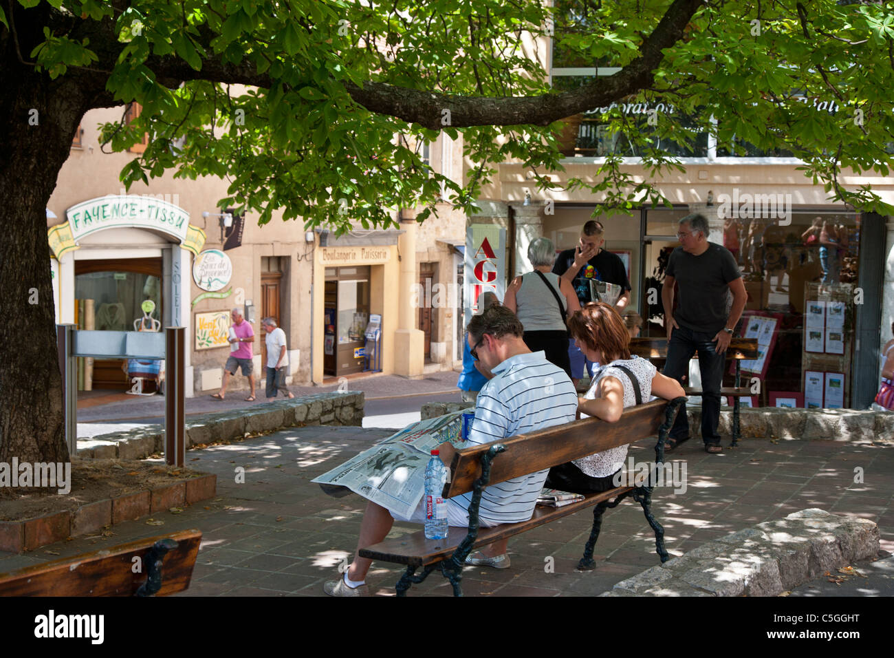 Les gens lisent les journaux et se détendre à l'ombre, Seillans, Provence, France Banque D'Images