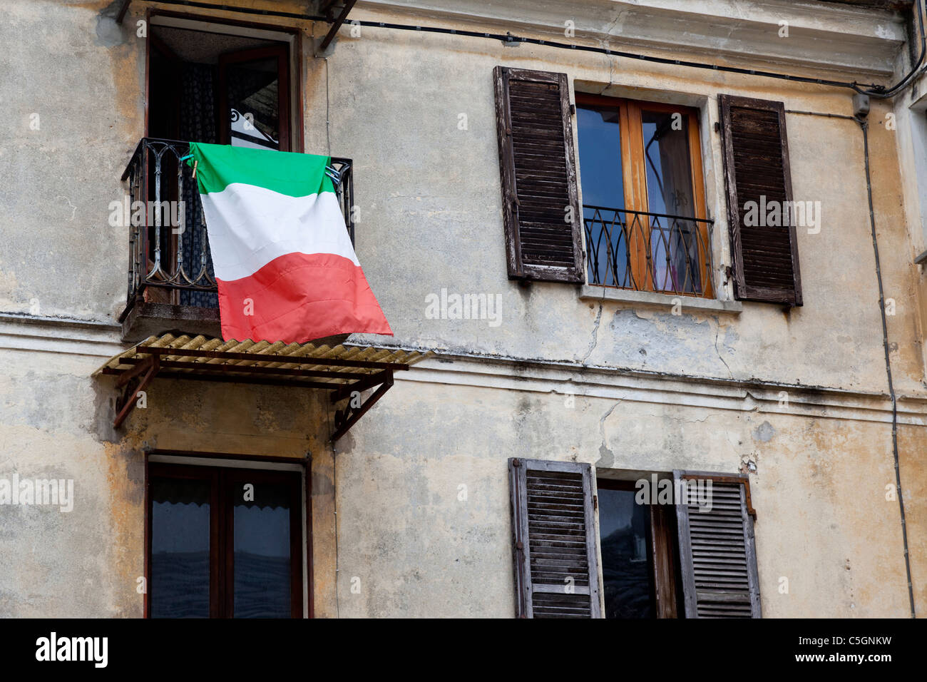 Drapeau Italien suspendu à une fenêtre d'une vieille maison, Quincinetto, Italie Banque D'Images