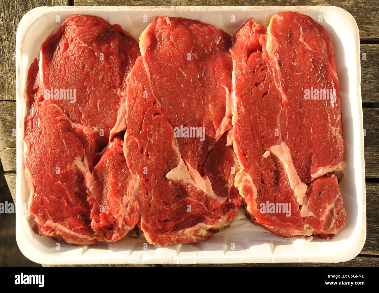 Steaks de boeuf et non cuits dans un carton Banque D'Images