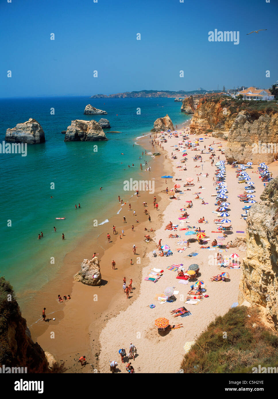 Des parasols, des piles de la mer et le soleil sur les plages de la Méditerranée le long de la plage Praia da Rocha au Portugal Banque D'Images