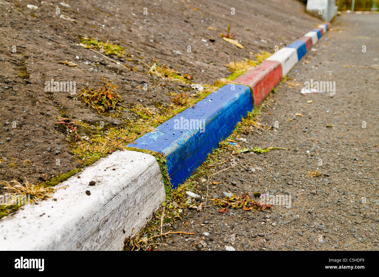 Rouge, blanc et bleu des pierres dans une bordure peinte rue Belfast Banque D'Images