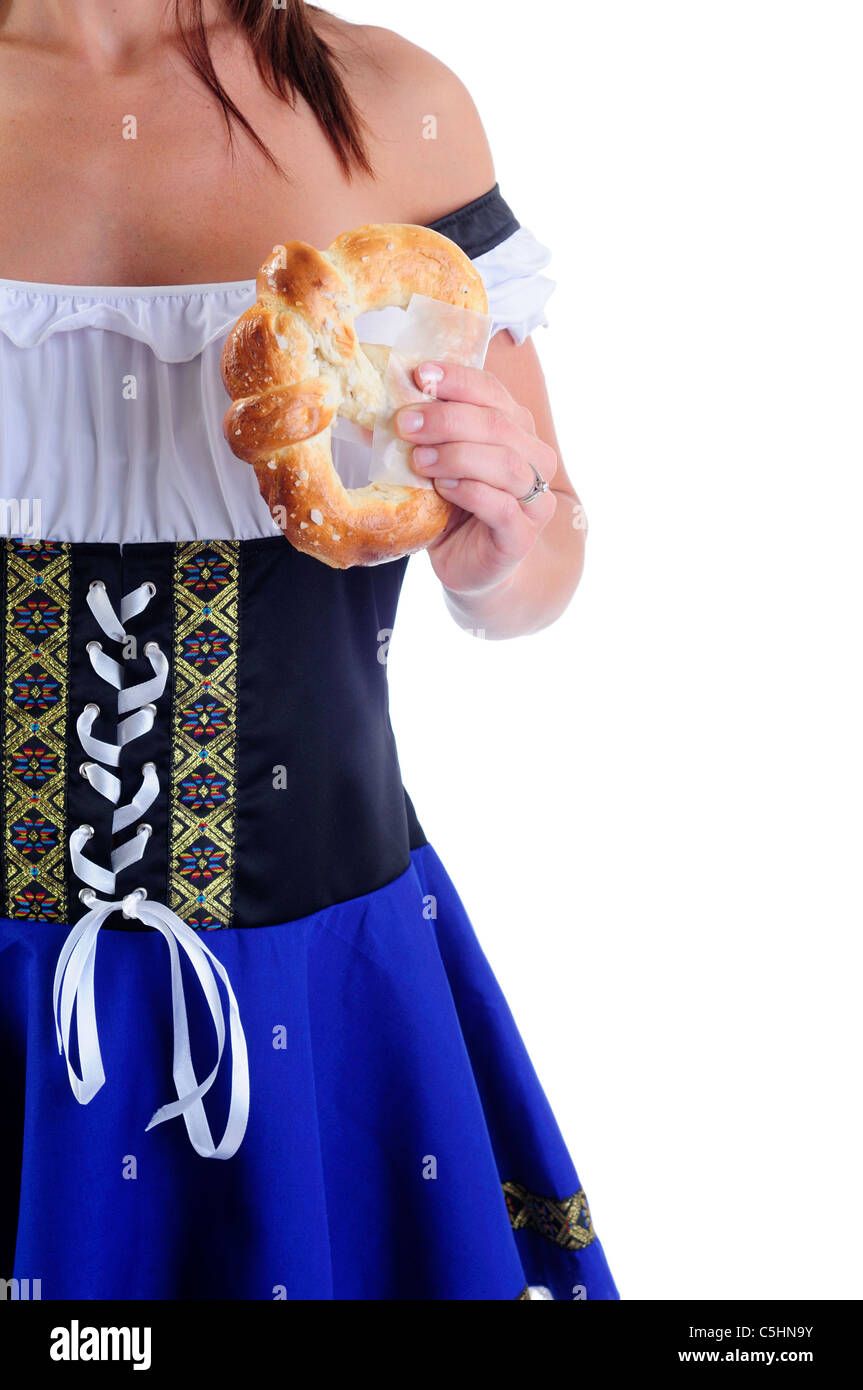 Belle femme portant un costume traditionnel pour l'Oktoberfest Dirndl Bleu Célébrations tenant un bretzel Frais Banque D'Images