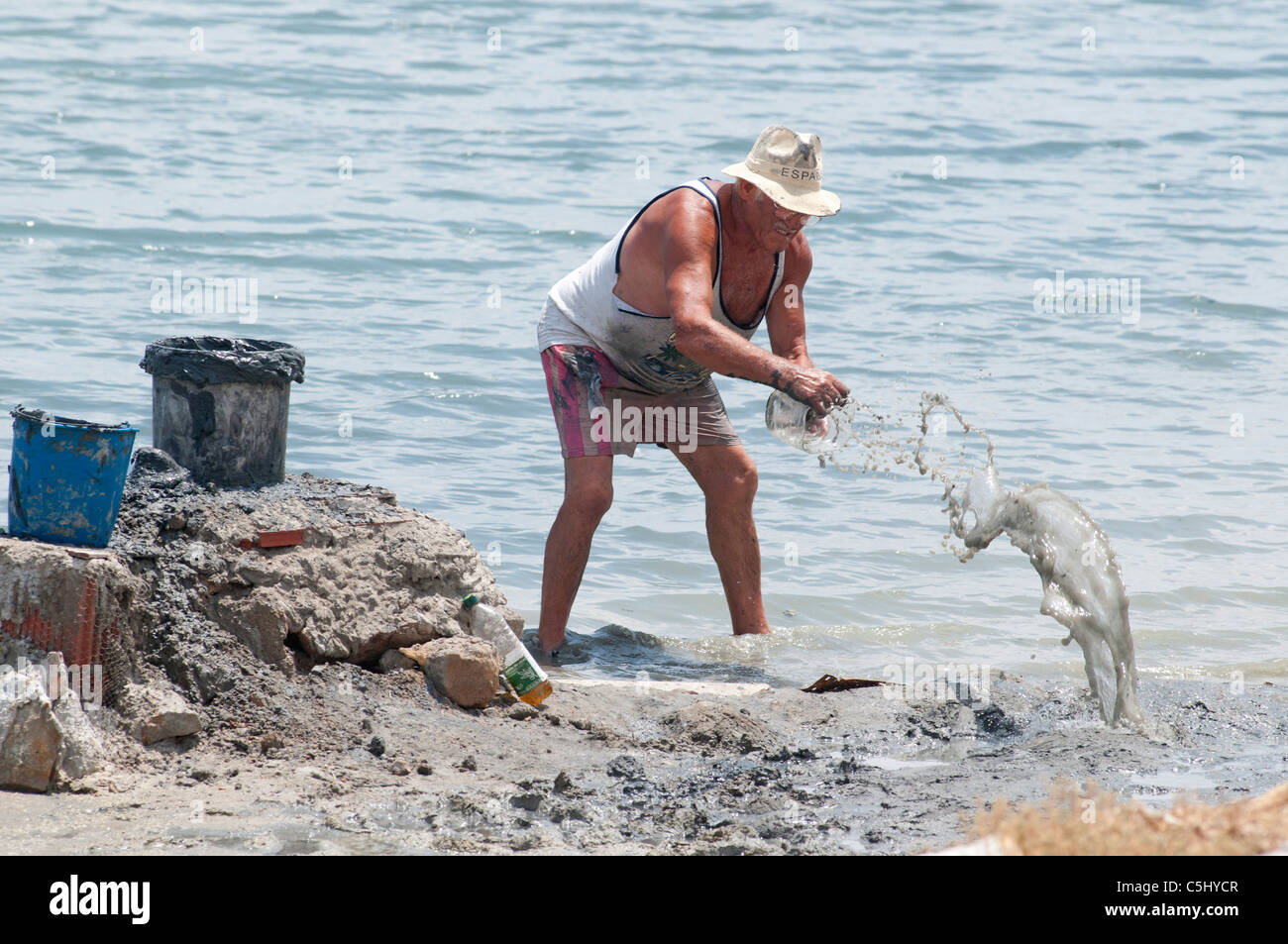 L'homme Local creuse à boue thérapeutique sur le littoral à Lo Pagan, Région de Murcie, Espagne, Europe du sud-est Banque D'Images