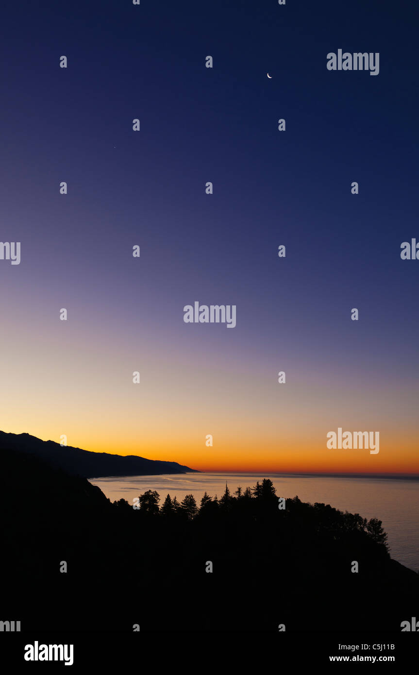 Croissant de lune et l'aube lumière sur la côte de Big Sur, en Californie Banque D'Images