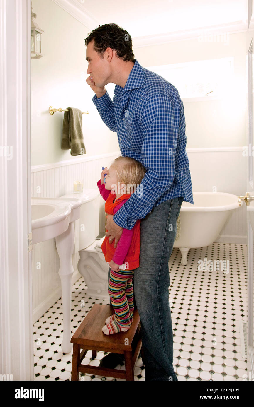 Un père et sa fille sont dans la salle de bain se brosser les dents. Banque D'Images