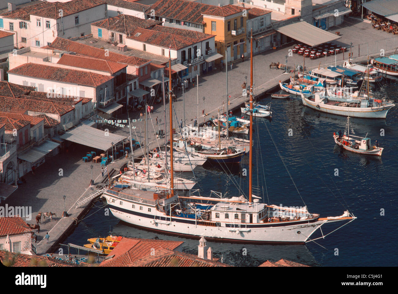 Bateaux amarrés le long du quai dans le port d'Hydra avec ses bâtiments de tuiles rouges, l'île de Hydra, Grèce Banque D'Images