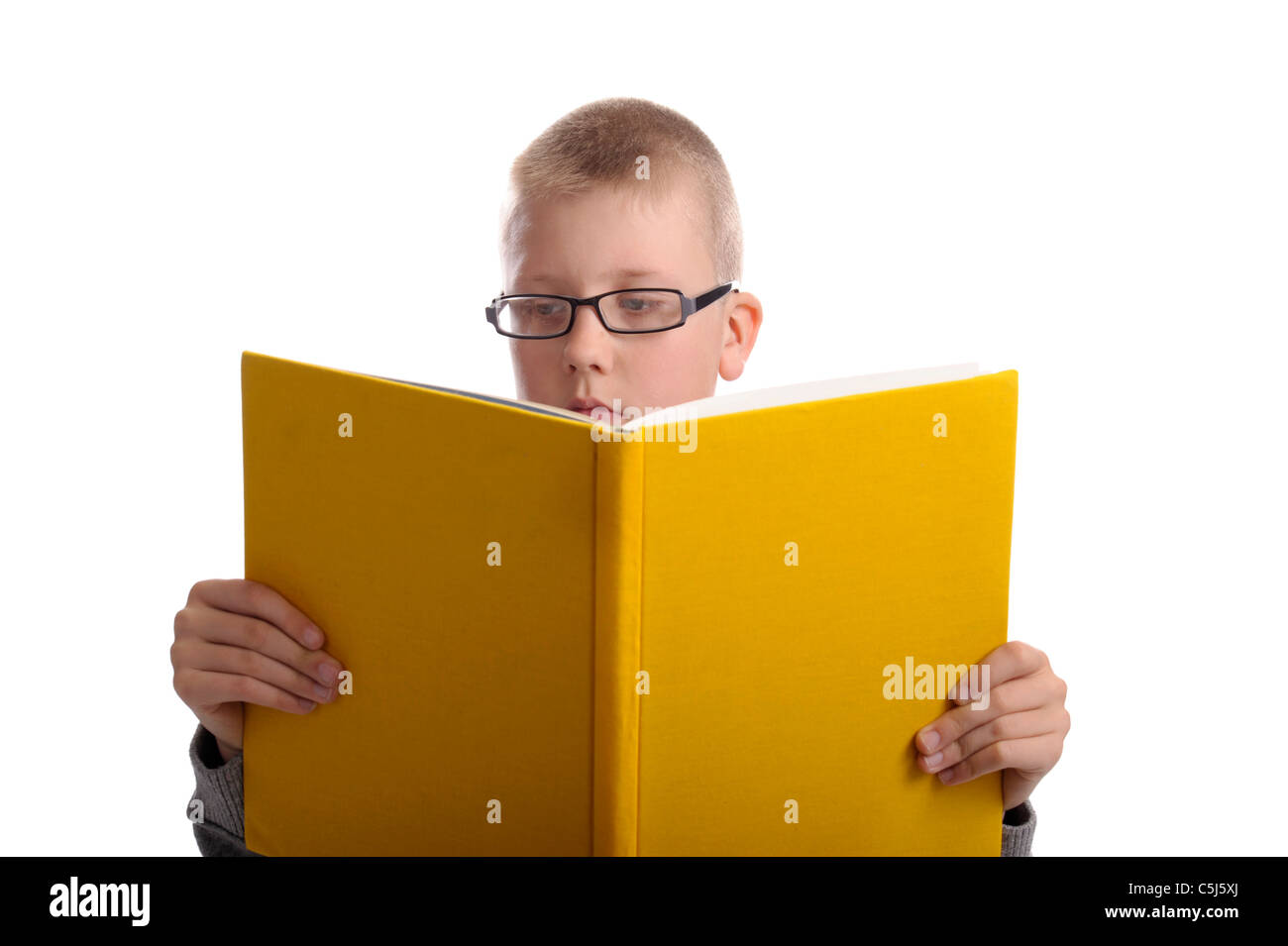 Garçon avec des lunettes de la lecture d'un livre jaune. Isolé sur fond blanc Banque D'Images