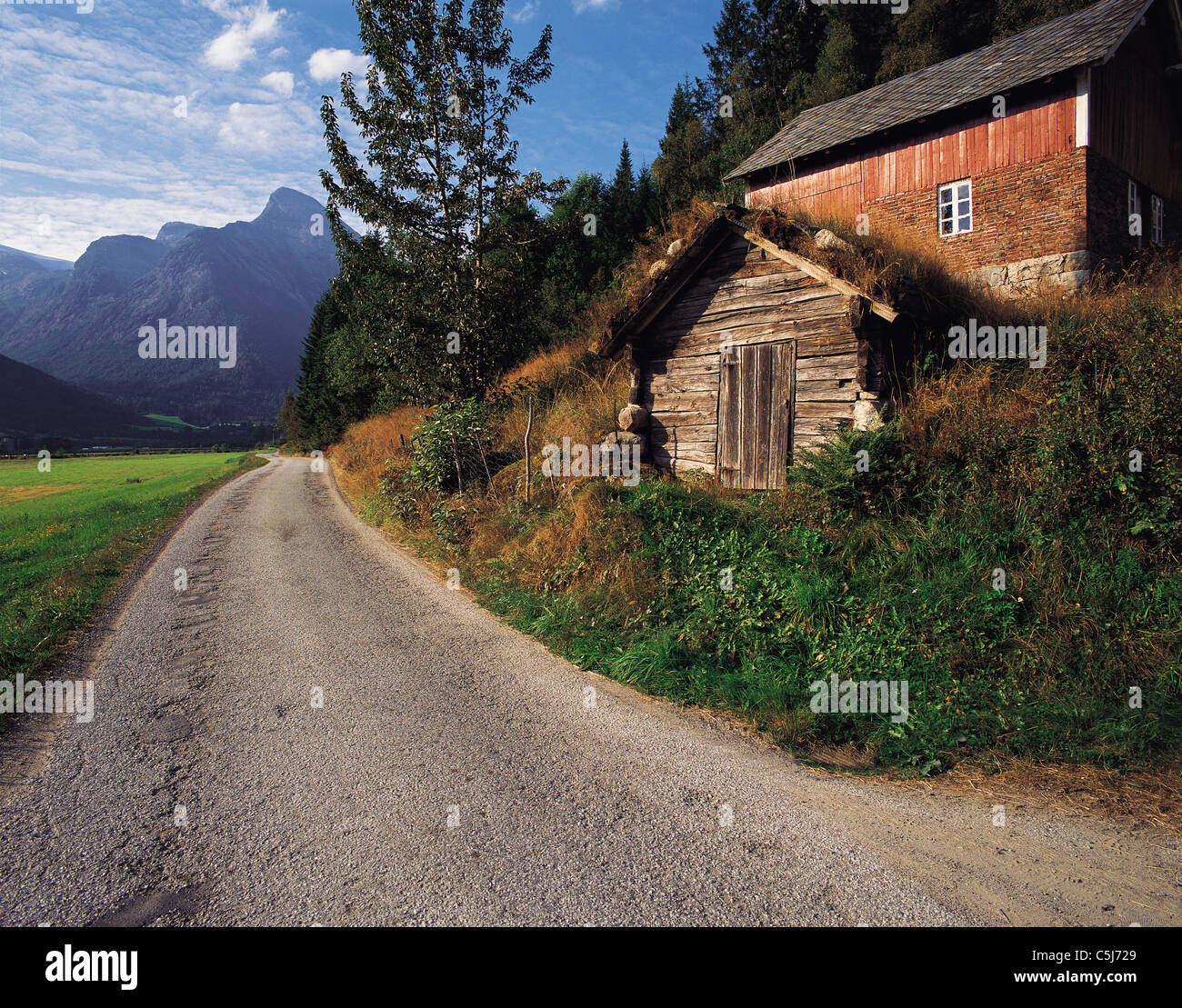 Un chemin de campagne et bâtiments en bois rustique dans la région montagneuse du district, la Norvège Fjaerland Banque D'Images