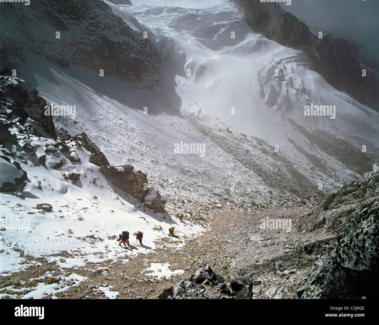 Porteurs à venir le dernier des pentes pour un pass au Lapsang La de glaciers ci-dessous dans la région de l'est Népal Kangchenjunga Banque D'Images