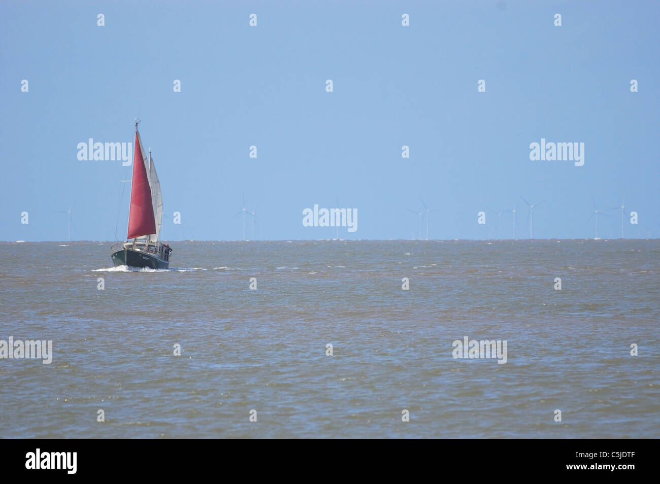 Yacht avec voile rouge s'approchant de la bouche de l'estuaire de Wyre Fleetwood Banque D'Images