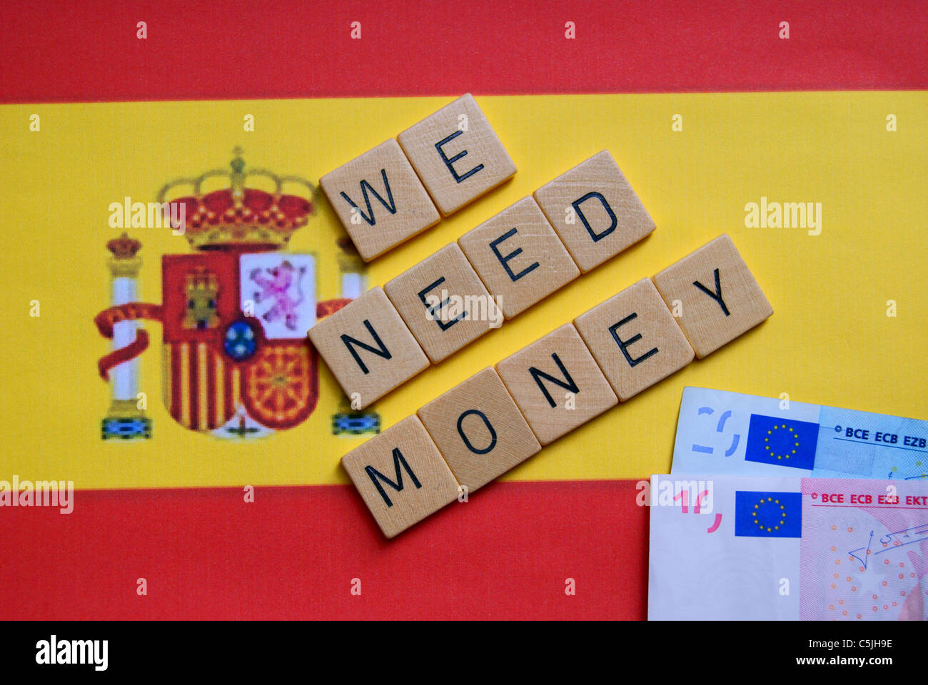 Nous avons besoin d'argent en toutes lettres sur un drapeau de l'Espagne Banque D'Images